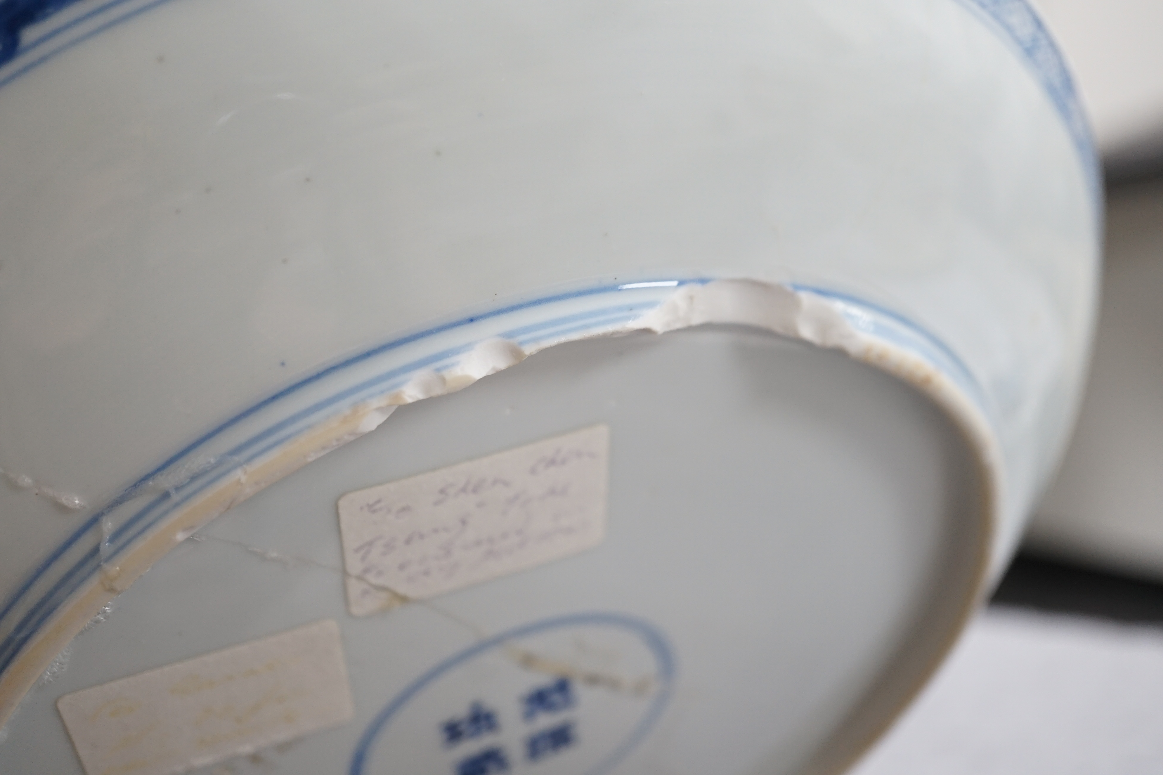 A Chinese blue and white dish, Kangxi period, broken and messily reglued